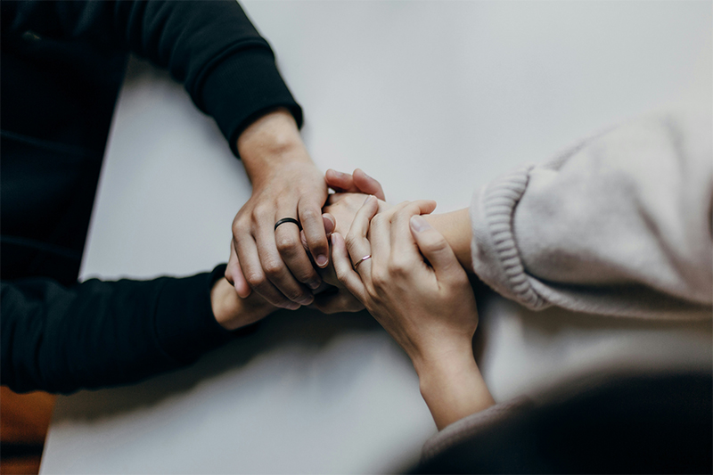 A couple holding hands over a table